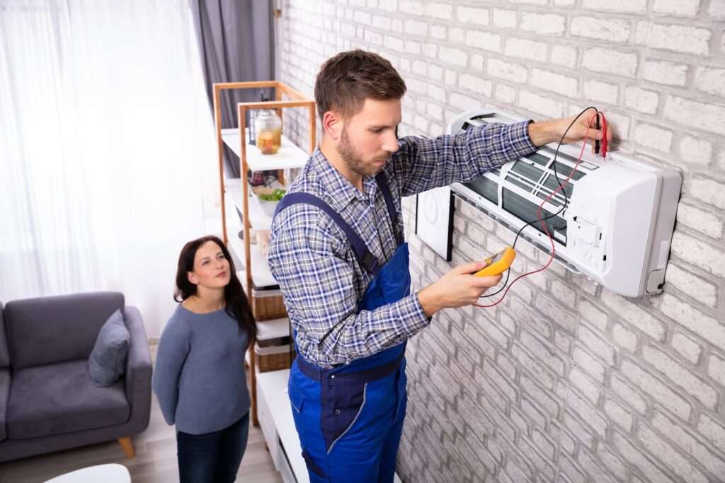 Installateur de climatisation vérifiant le bon fonctionnement du système installé